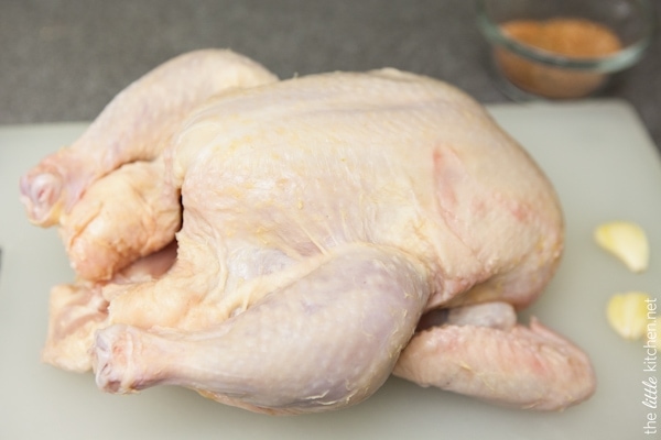 Crockpot Whole Chicken from TheLittleKitchen.net whole chicken on a cutting board with garlic