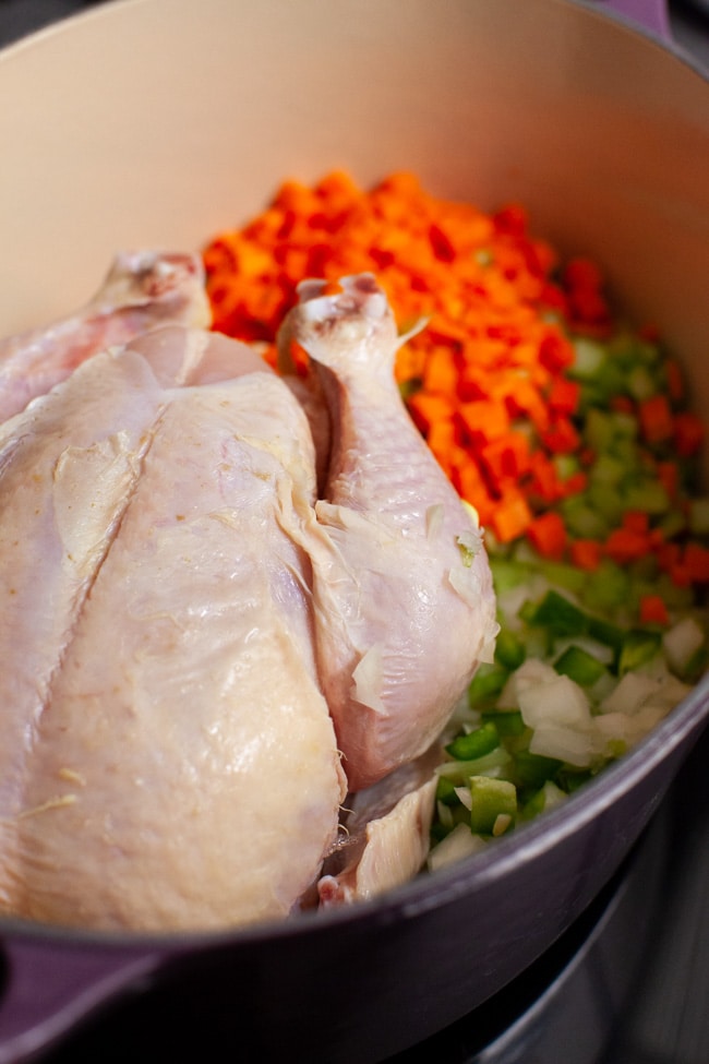 Spicy Chicken Soup from thelittlekitchen.net a whole chicken in a pot with chopped carrots, celery and onions