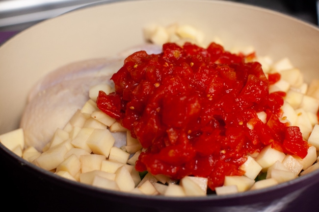 Spicy Chicken Soup from thelittlekitchen.net a pot with a whole chicken, chopped potatoes and diced canned tomatoes on top