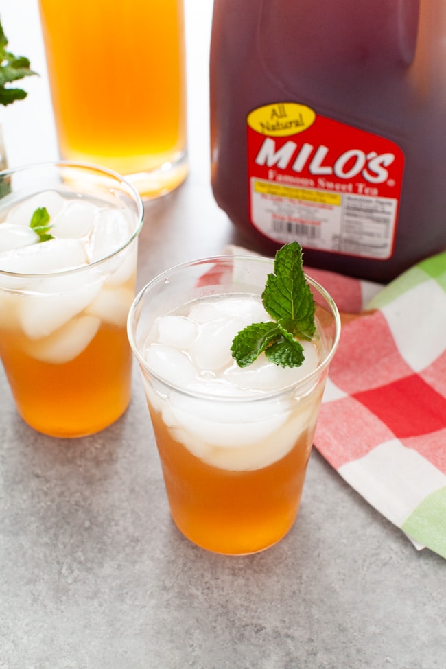Sweet Tea with Vodka and Lemonade from thelittlekitchen.net glasses with sweet tea vodka and lemonade with jug of Milo's Sweet Tea in the background