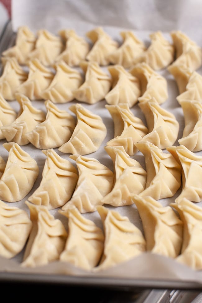 Vegetarian Dumplings from thelittlekitchen.net Parchment-lined baking sheet with uncooked Vegetarian Dumplings from thelittlekitchen.net