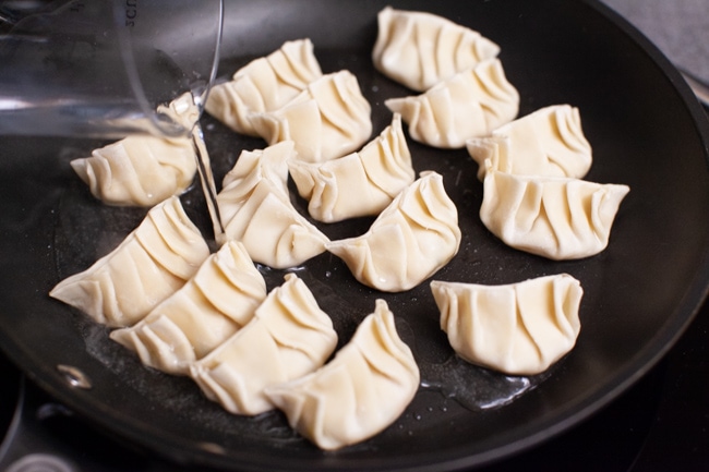 Vegetarian Dumplings from thelittlekitchen.net Water being poured into skillet of Vegetarian Dumplings from thelittlekitchen.net