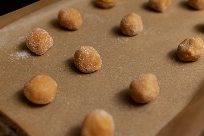 Peanut Butter Blossom Cookies from thelittlekitchen.net Peanut Butter Blossom Cookie dough balls on a parchment paper lined baking sheet.