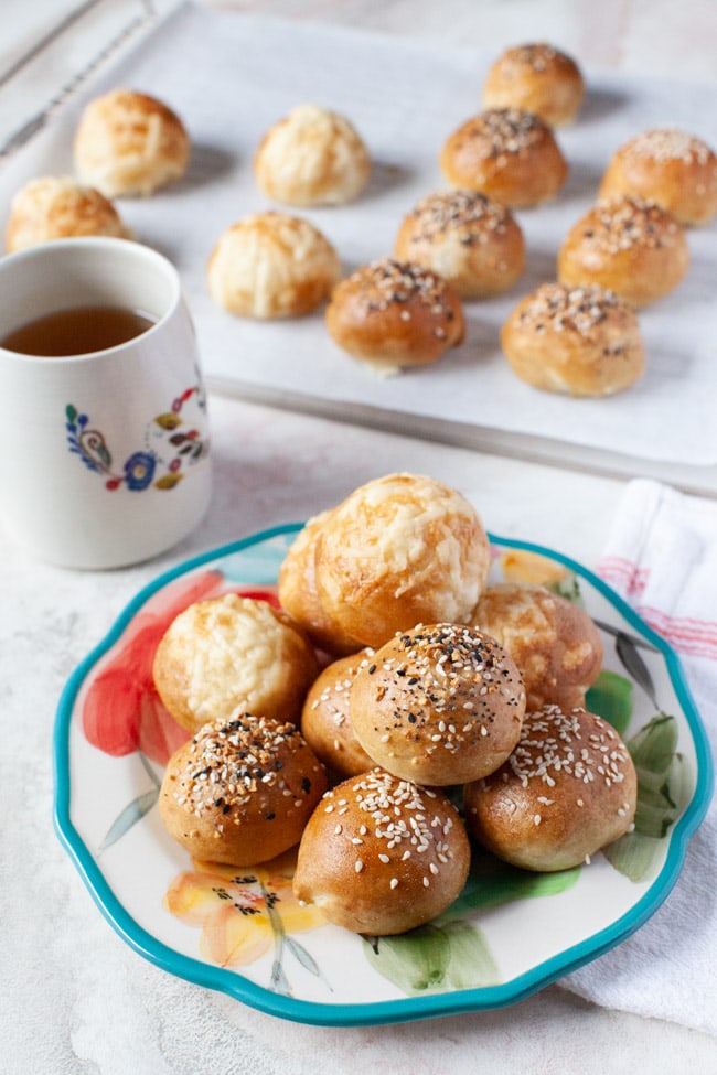 Stuffed Bagel Bites from thelittlekitchen.net stuffed bagel bites on a floral plate with a cup of tea in the background along with more stuffed bagel bites