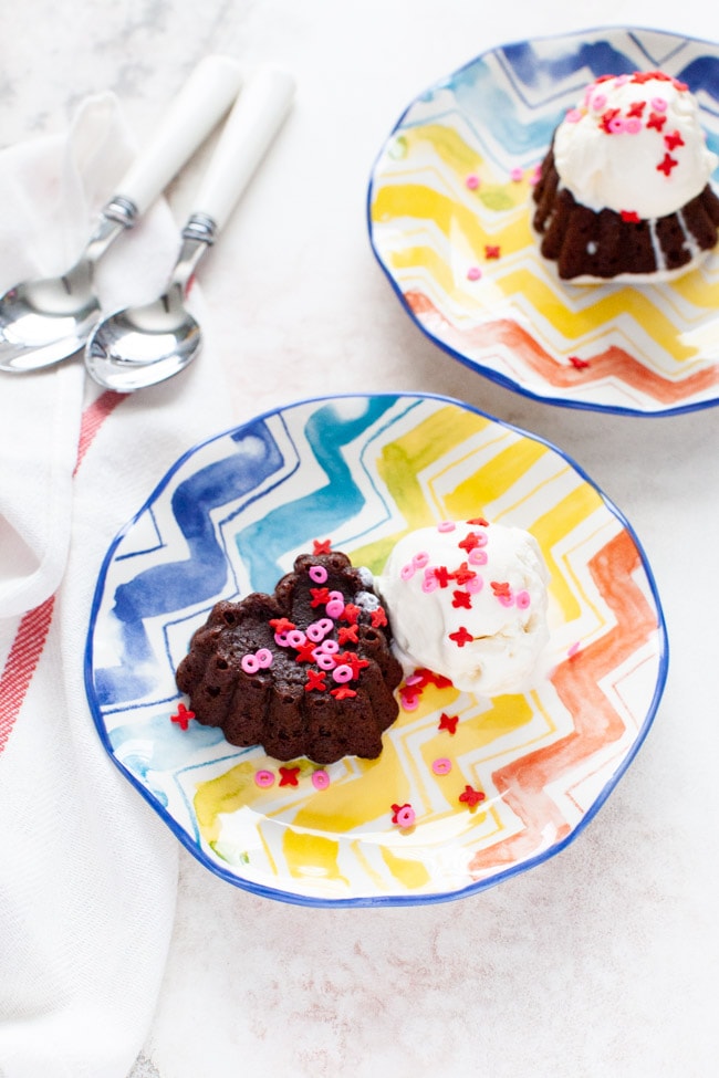 Heart Shape Chocolate Cake from thelittlekitchen.net heart shaped chocolate cake with vanilla ice cream on a plate with spoons another plate in the background