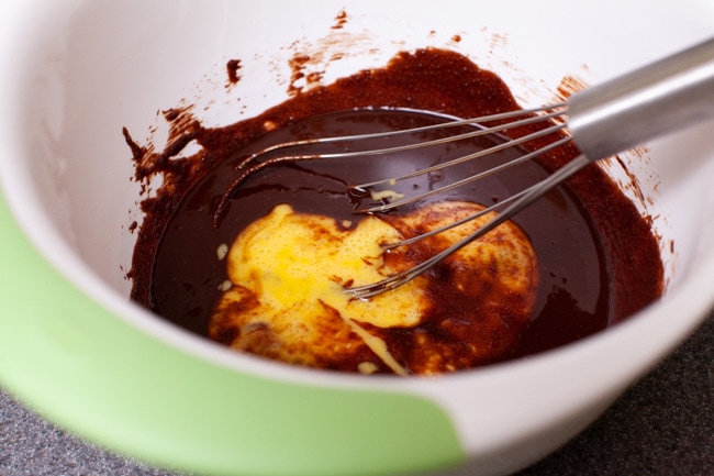 Heart Shape Chocolate Cake from thelittlekitchen.net beaten eggs in a mixing bowl with melted chocolate and a whisk