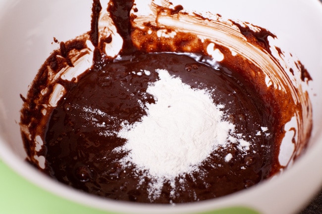 Heart Shape Chocolate Cake from thelittlekitchen.net flour on top of a chocolate mixture in a mixing bowl