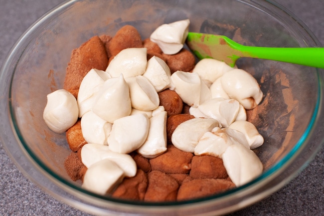 Easy Monkey Bread with Nutella from thelittlekitchen.net dough balls that have been rolled in a cinnamon and sugar mixture sitting in a glass bowl.