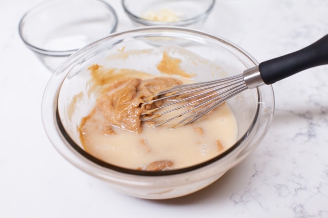 How to Make Peanut Sauce from thelittlekitchen.net making peanut sauce in a glass mixing bowl with a whisk