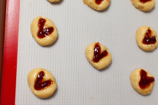 Heart-Shaped Thumbprint Cookies from thelittlekitchen.net heart shaped thumbprint cookies on a silicon baking mat