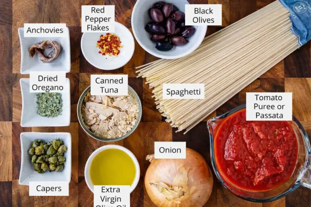 Pantry ingredients for easy tuna pasta including tuna in olive oil, passata, olives, capers, and spaghetti