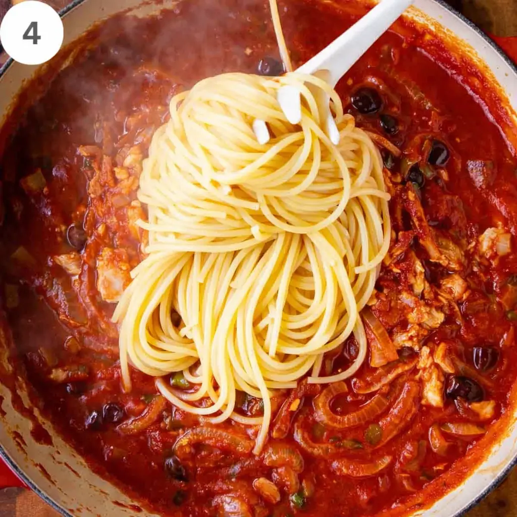 Tossing spaghetti with tuna tomato sauce
